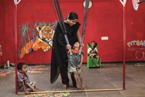 Una cuidadora ayuda a unos niños a practicar ejercicios para mejorar su movilidad en el Centro de Parálisis Cerebral de Bathalapalli. © Cristina García Rodero.